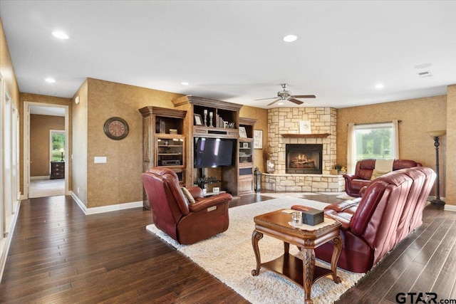 living room featuring ceiling fan, dark hardwood / wood-style floors, and a fireplace