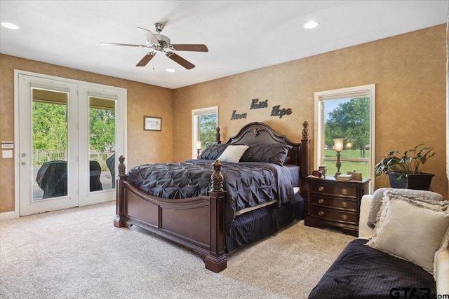 carpeted bedroom with ceiling fan, multiple windows, french doors, and access to outside