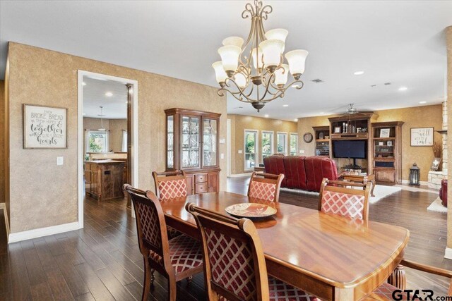 dining space featuring dark wood-type flooring and a chandelier