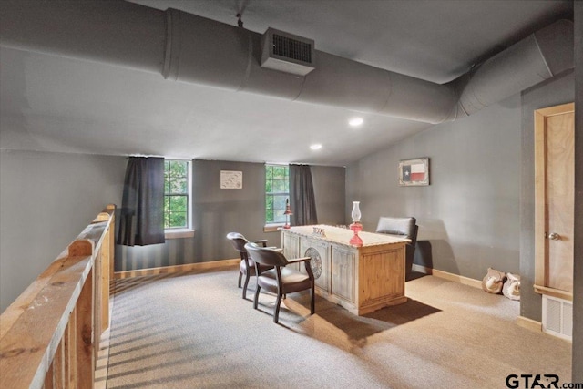 carpeted home office with vaulted ceiling