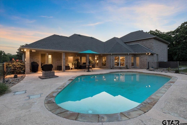 pool at dusk with a patio