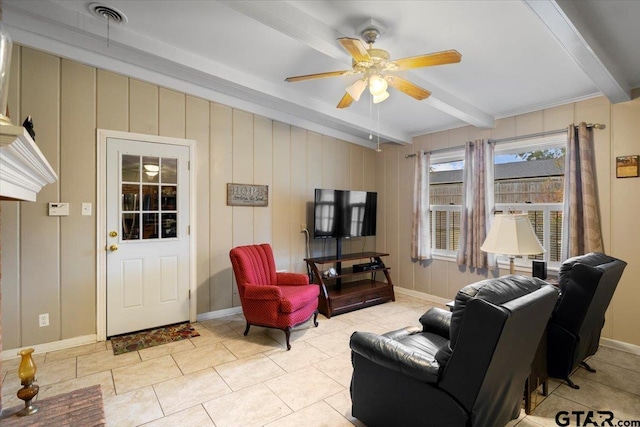 tiled living room with beamed ceiling, ceiling fan, and wood walls