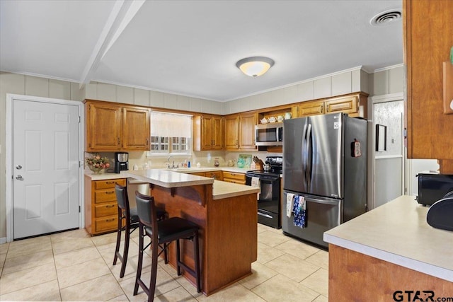 kitchen featuring a center island, crown molding, stainless steel appliances, and a breakfast bar area