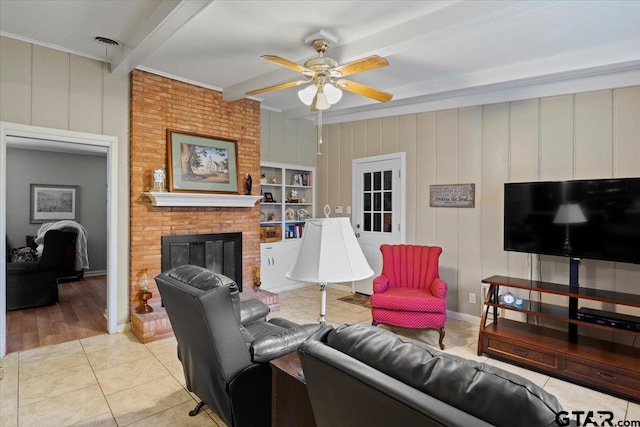 living room with ceiling fan, beam ceiling, a fireplace, and light hardwood / wood-style flooring