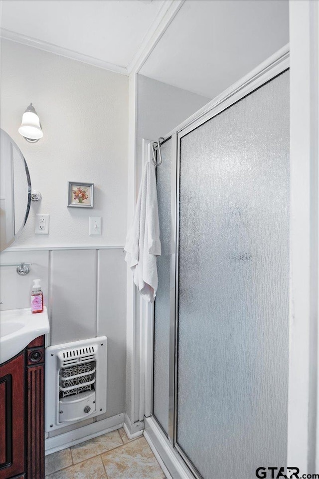 bathroom featuring vanity, heating unit, an enclosed shower, and ornamental molding