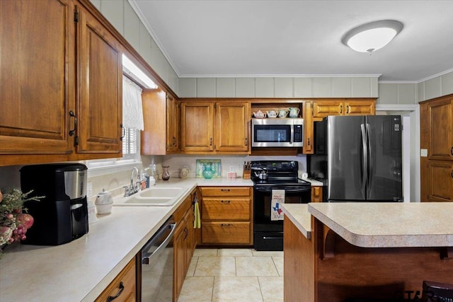 kitchen with a kitchen breakfast bar, sink, light tile patterned floors, ornamental molding, and appliances with stainless steel finishes