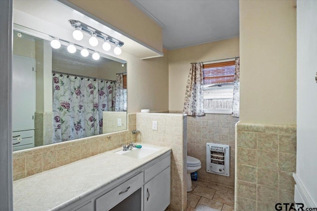 bathroom featuring vanity, tile patterned floors, toilet, tile walls, and heating unit