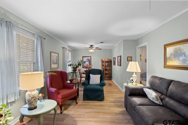 living room with ceiling fan, ornamental molding, and light wood-type flooring