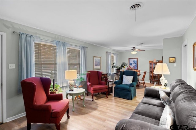 living room featuring crown molding, light hardwood / wood-style flooring, and ceiling fan