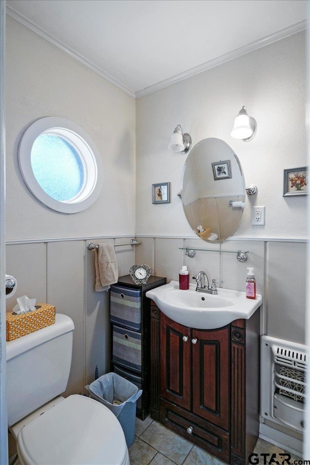 bathroom featuring tile patterned floors, heating unit, crown molding, toilet, and vanity