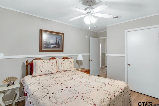 bedroom with light wood-type flooring, ceiling fan, and crown molding