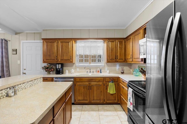 kitchen featuring crown molding, sink, light tile patterned floors, and appliances with stainless steel finishes