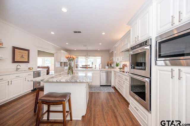 kitchen with visible vents, dark wood-type flooring, appliances with stainless steel finishes, and white cabinets