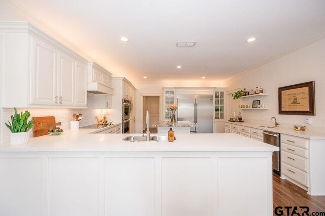 kitchen featuring visible vents, a peninsula, stainless steel appliances, and a sink