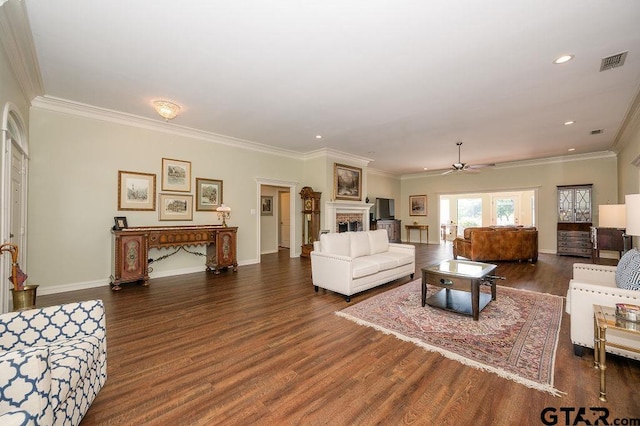 living room featuring wood finished floors, crown molding, a ceiling fan, and visible vents