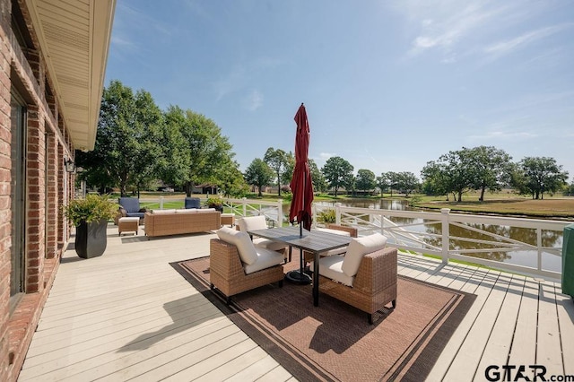 wooden terrace with a water view and outdoor lounge area