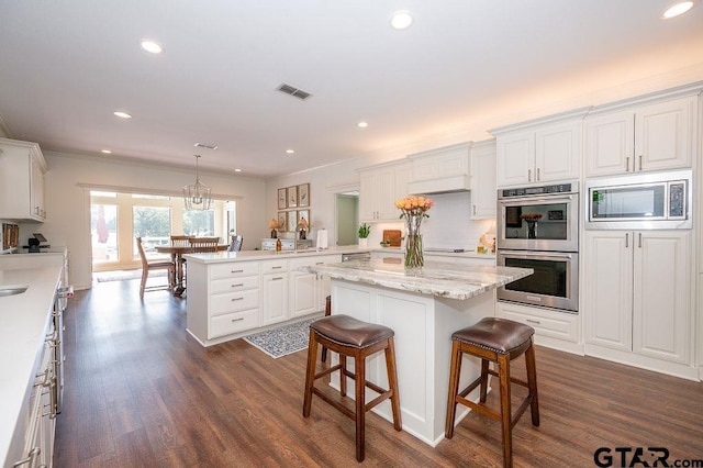 kitchen with visible vents, appliances with stainless steel finishes, a peninsula, and white cabinetry