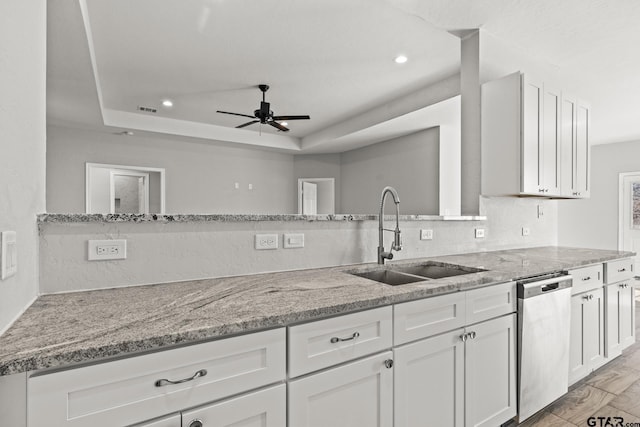 kitchen featuring a raised ceiling, dishwasher, white cabinets, and sink