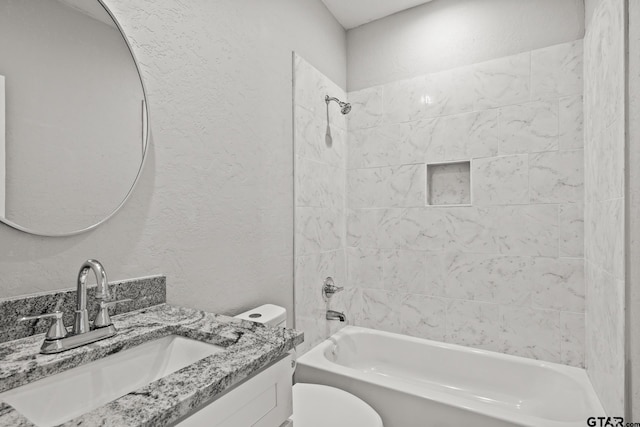 full bathroom with vanity, tiled shower / bath combo, and toilet