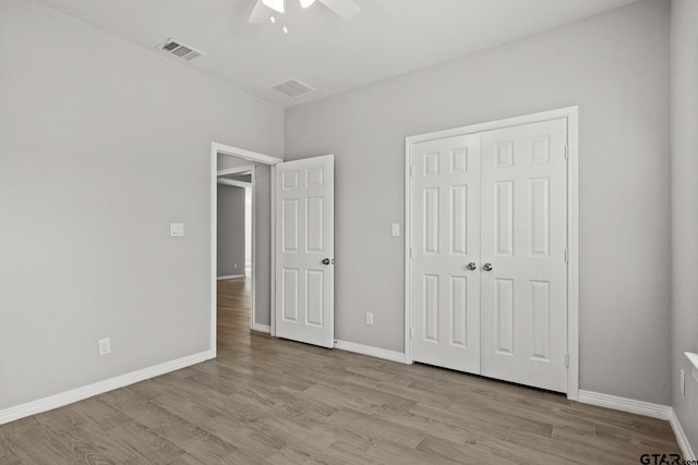 unfurnished bedroom with light wood-type flooring, a closet, and ceiling fan