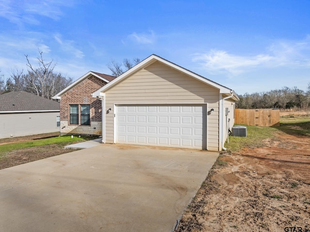 view of front of home with a garage and central AC