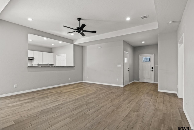 unfurnished living room with ceiling fan and light wood-type flooring