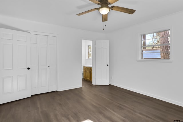 unfurnished bedroom featuring a closet, dark hardwood / wood-style floors, ceiling fan, and ensuite bath