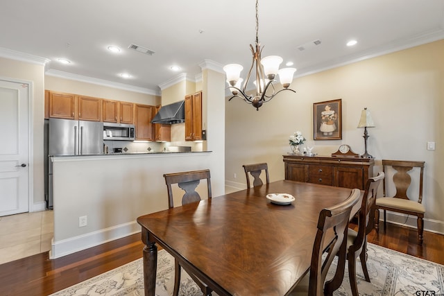 dining room featuring ornamental molding, dark hardwood / wood-style flooring, and a notable chandelier