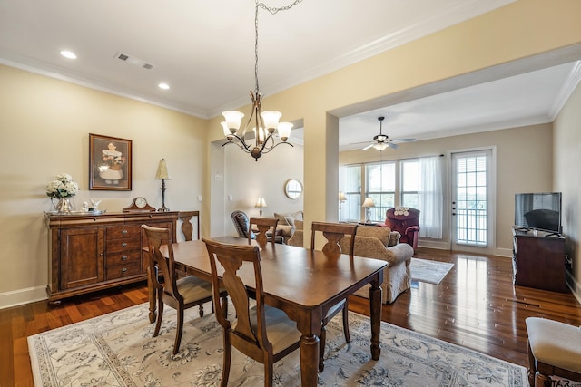 dining area with ceiling fan with notable chandelier, dark hardwood / wood-style floors, and crown molding