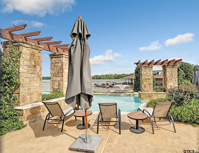 view of patio with a pergola and a water view