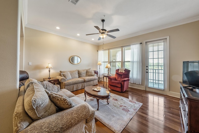 living room with dark wood-type flooring, ceiling fan, and crown molding