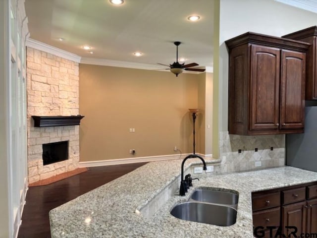 3673 Southwood Dr, Tyler, TX 75707 - kitchen featuring dark brown cabinets, ornamental molding, and a sink