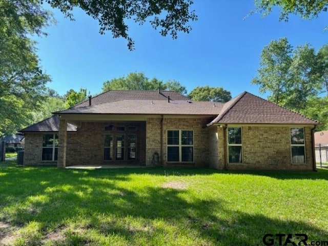 3673 Southwood Dr, Tyler, TX 75707 - back of property with a lawn, fence, and brick siding