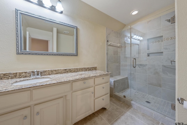 bathroom featuring tile patterned floors, vanity, and walk in shower