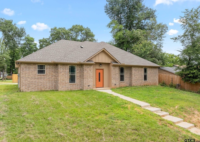 ranch-style home featuring fence, a front lawn, and brick siding