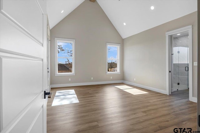 unfurnished bedroom with hardwood / wood-style flooring and high vaulted ceiling