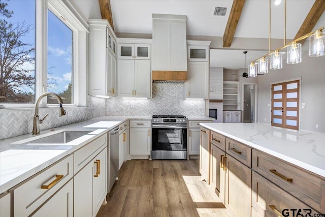 kitchen featuring pendant lighting, sink, white cabinetry, stainless steel appliances, and light stone counters