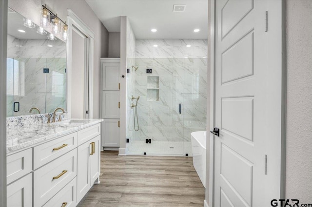 bathroom featuring vanity, separate shower and tub, and hardwood / wood-style floors