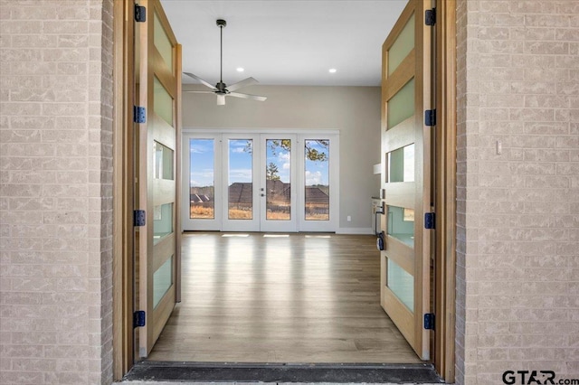 hall featuring hardwood / wood-style flooring and brick wall