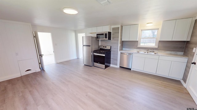 kitchen with a sink, light countertops, appliances with stainless steel finishes, and white cabinets