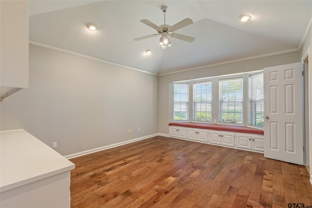 interior space with ornamental molding, ceiling fan, lofted ceiling, and wood-type flooring