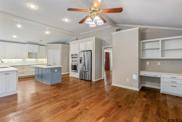 kitchen featuring white cabinets, vaulted ceiling with beams, a kitchen island, and appliances with stainless steel finishes