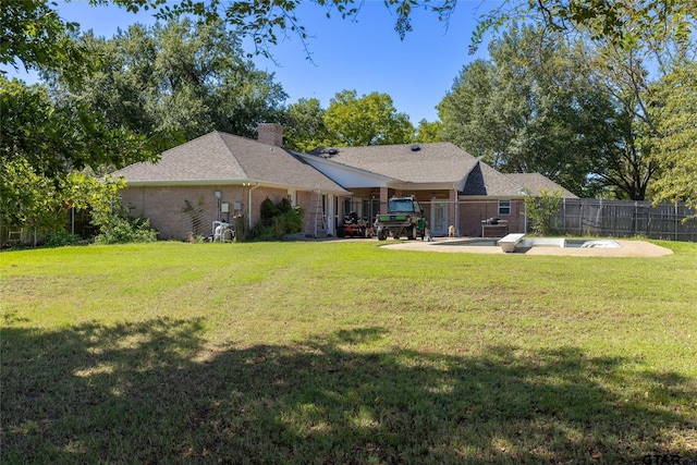 rear view of property featuring a yard and a patio