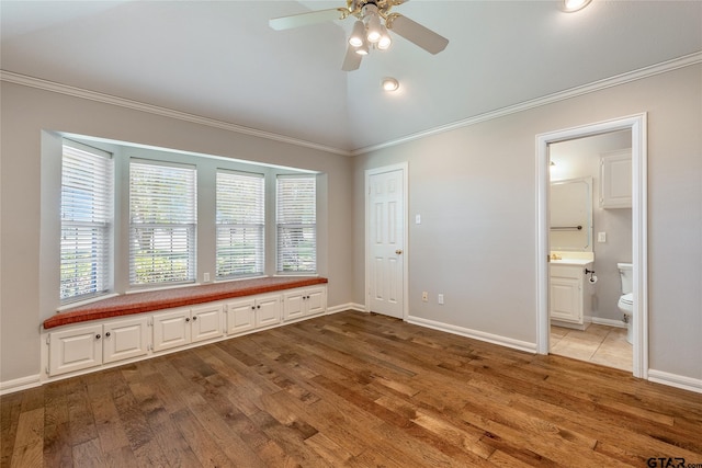 unfurnished bedroom with ornamental molding, ensuite bath, ceiling fan, and lofted ceiling