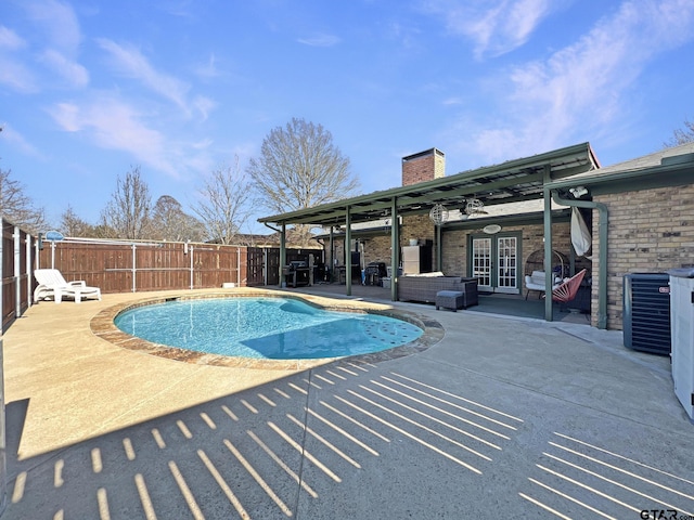 view of swimming pool featuring a fenced in pool, french doors, a patio area, central AC, and a fenced backyard