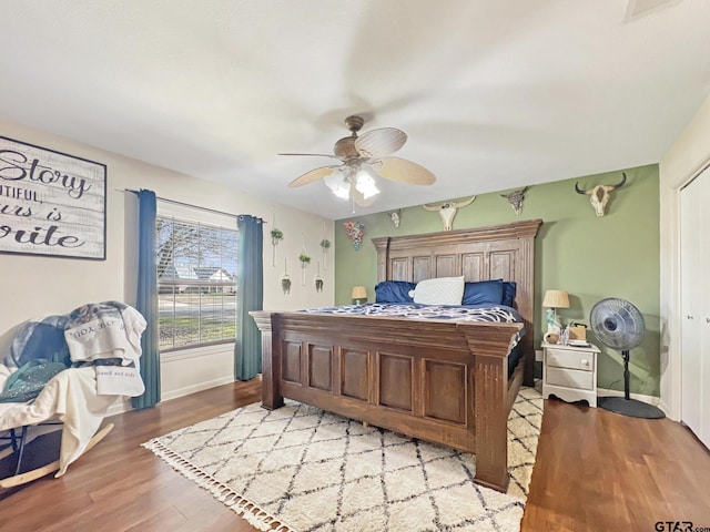 bedroom with ceiling fan, baseboards, and wood finished floors