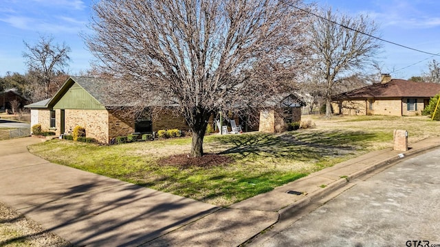 view of front of property with brick siding and a front lawn