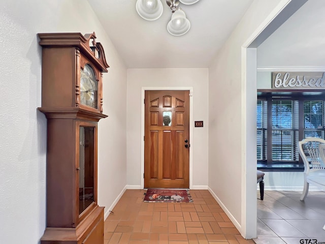 entrance foyer featuring brick floor and baseboards