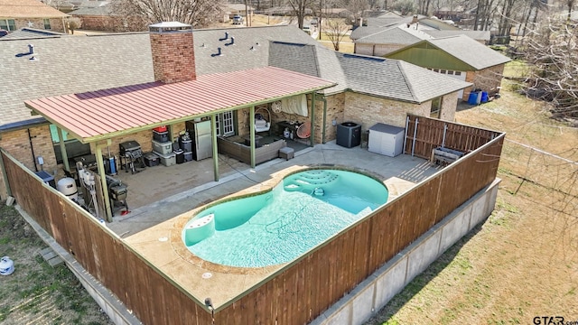 view of pool with central AC, a patio area, and a fenced backyard