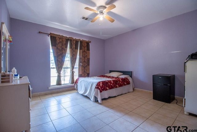 tiled bedroom with ceiling fan and black fridge